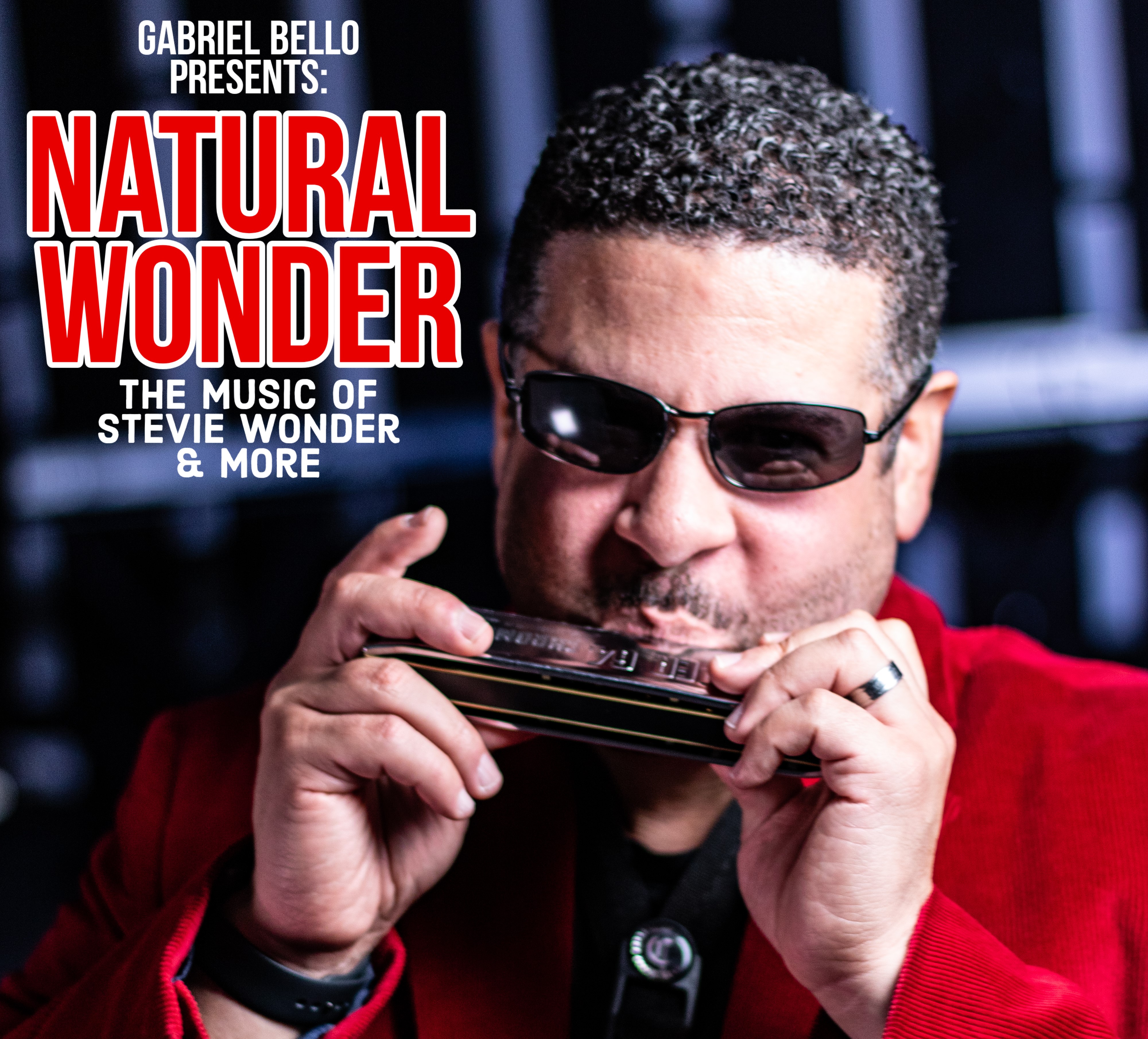 Man playing harmonica wearing a red suit jacket.